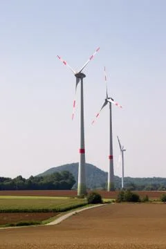 Three wind turbines in a hilly landscape Stock Photos