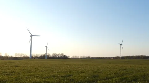 Three wind turbines on a wintry meadow in backlight - slow motion Stock Footage 106509545