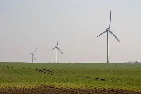 Three windmills in a field Stock Photos