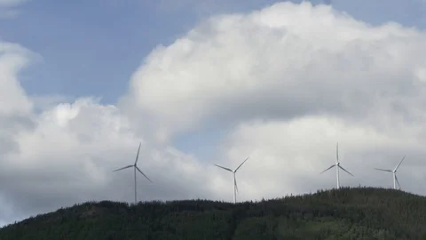 Three windmills turning on a mountain ridge with clouds blowing by. Vidéo 88999172