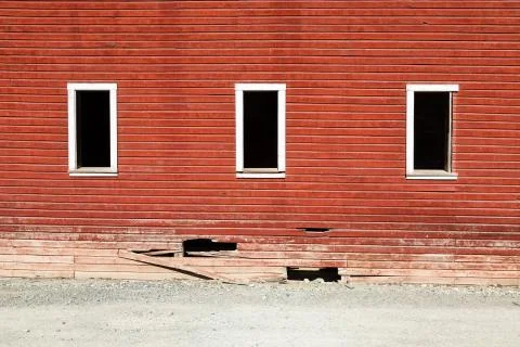 Three window frames on broken red wall of ghost town in Kennicott, Alaska Stock Photos