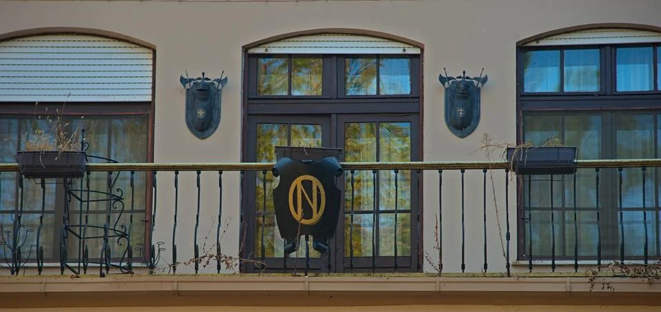 Three windows with decorations on facade Stock Photos