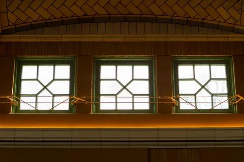 Three windows with geometric designs in a building showing light from outsi.. Stock Photos