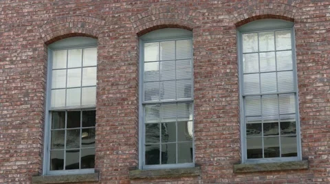 Three windows on the old English style brick building's wall. Stock-Footage 62763154