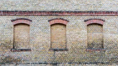 Three windows of an old house are bricked up Foto stock