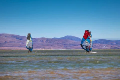 Three windsurfers from a surf school practice in a lagoon on the Canary Islan Stock Photos