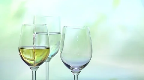 Three wine glasses, white wine being poured into one of them Stock Footage 8570650