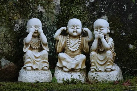 Three wise monkeys statues in a garden Stock Photos