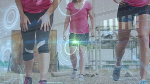Three women approaching camera, doing step lunges on sand, fitness HUD pulsing Stock Footage 332523323