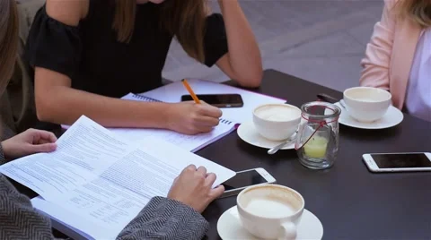 Three women are learning at cafe restaurant, one of them is using a mobile phone Video stock 67782930