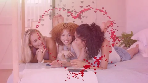 Three women chatting on bed red heart trail sparking moving heart framing faces Stock Footage 334369152