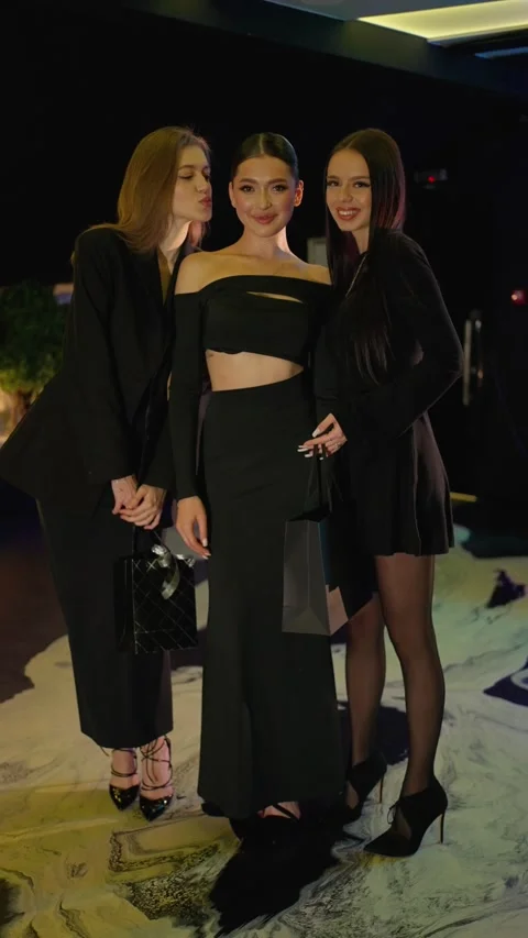 Three women in elegant clothes pose at evening event. Social party concept. Stock Footage 292642052
