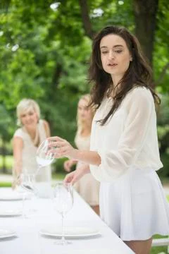 Three women setting a table outside Fotos Stock
