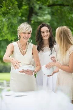 Three women setting a table outside Fotos Stock