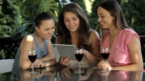 Three women with tablet drinking wine Stock Footage 26259217