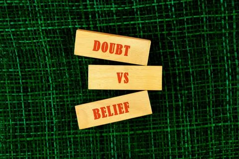 Three wooden blocks vertically stack displaying the words Doubt, VS, and Beli 스톡 사진