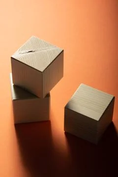 Three wooden cube on a orange background. Group of geometric shapes, top view Stock-Fotos