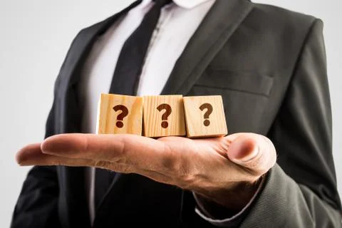 Three wooden cubes displaying question marks Foto stock