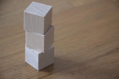 Three wooden cubes pt vertically on table background Stock Photos