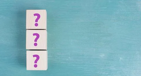 Three wooden cubes with question marks in purple color, searching for an a... Stock Photos