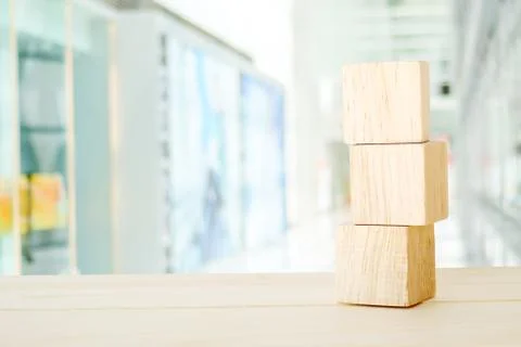 Three wooden cubes on table over blur abtract bokeh light background Stock Photos