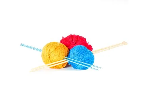 Three wool balls skewered by knitting needles. Stock Photos