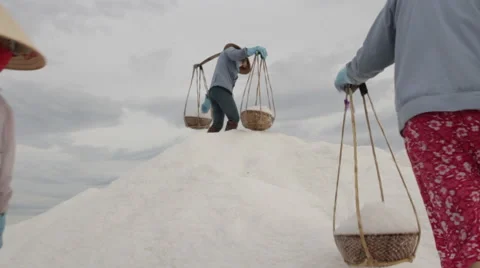 Three Workers Climb Large Hill to Dump Salt Stock Footage 42425912