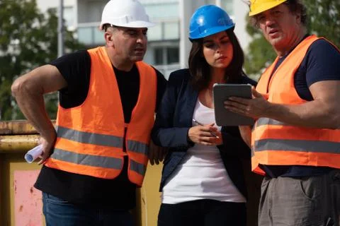 Three workers on construction site Stock Photos