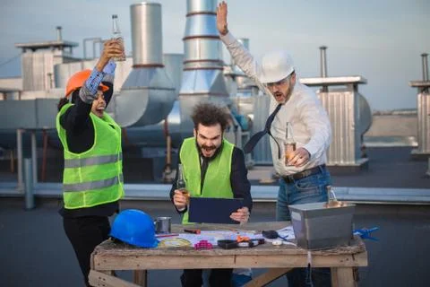 Three workers enjoy watching a funny video, after a hard day's work Stock Photos