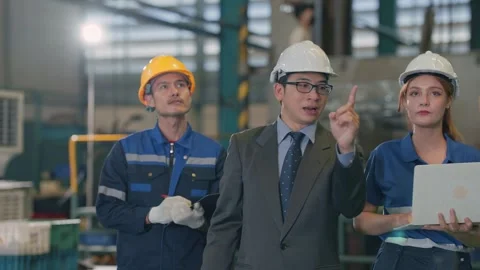 Three workers inspect a factory floor together 스톡 동영상 345135566