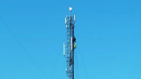 Three workers repair a cell tower. High-altitude work. Laying new cables Stock Footage 307845626