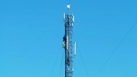Three workers repair a cell tower. Laying new cables. High-altitude work Stock Footage 310011938