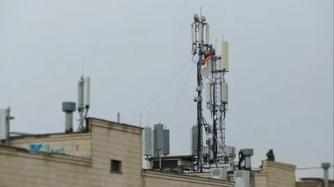 Three workers set up a huge antenna on the roof of a high-rise building Stock Footage 73664177