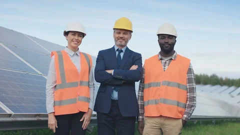 Three workers stand and look at camera o... | Stock Video | Pond5