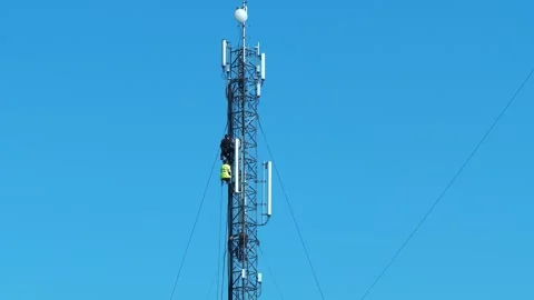 Three workmen on cell tower. Repairmen install new cable and equipment Stock Footage 319445127
