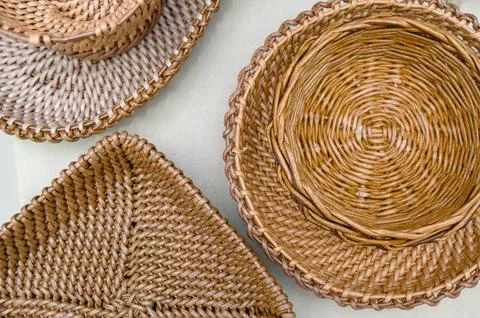 Three woven baskets in various shapes on a light background 스톡 사진