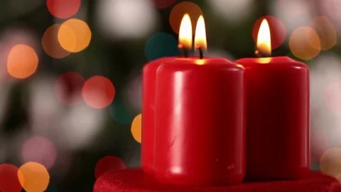 Three xmas candles spin in front of colorful blinking blurry lights Stock-Footage 81229120