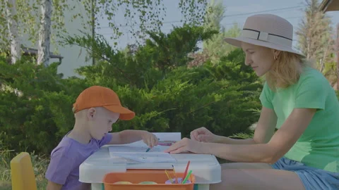 Three year old boy and his mother draw in home garden 2 Stock Footage 276879476