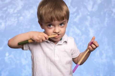 A three-year-old boy  brushes his teeth with a bamboo eco-friendly toothbrush Stock-Fotos