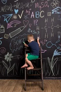 Three-year-old boy draws with multi-colored chalk Stock Photos