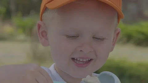 Three year old boy eating porridge in home garden 3v2 Stock Footage 277076659