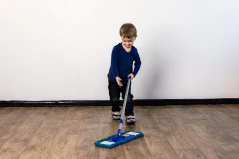 Three year old boy mops the floor in the apartment. Stock Photos