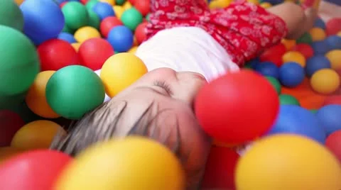 Three year old boy in a pool of coloured balls Stock Footage 11448017