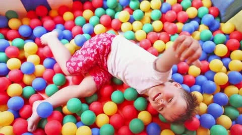 Three year old boy in a pool of coloured balls Stock Footage 11448266