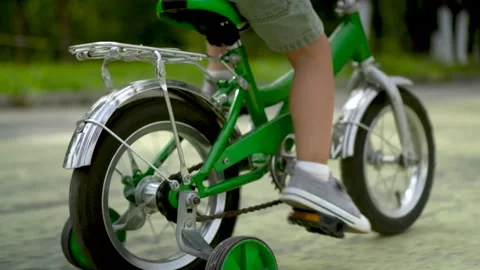 Three year old boy rear view riding green kids bicycle on path in park Vidéo 331285186