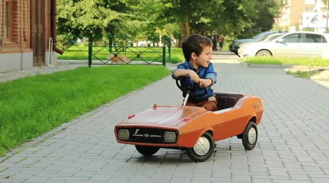 The three-year old boy riding a toy car Stock Footage 27573250