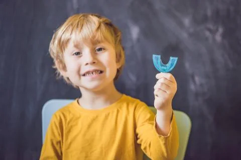 Three-year old boy shows myofunctional trainer. Helps equalize the growing te Stock Photos