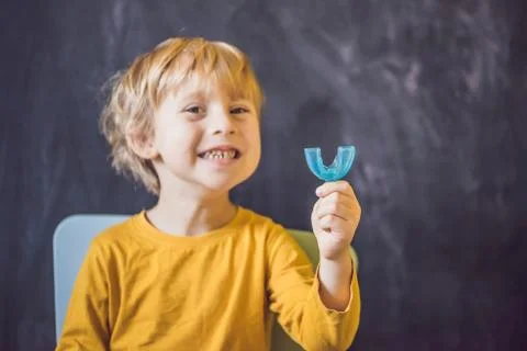 Three-year old boy shows myofunctional trainer. Helps equalize the growing teeth Stock Photos