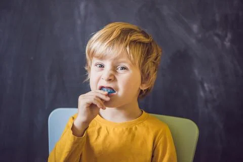 Three-year old boy shows myofunctional trainer. Helps equalize the growing teeth Stock Photos