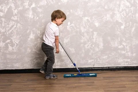 Three year old boy washes the floor in the apartment Stock-Fotos